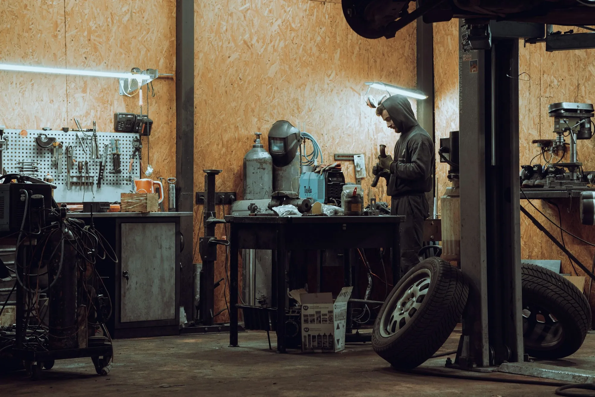 Repair workshop with workbenches, tools and a vehicle lift